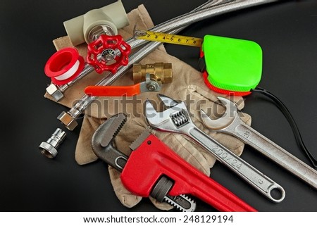 Plumbing tools on black background.