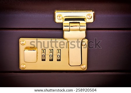 Close-up of suitcase\'s golden code lock.