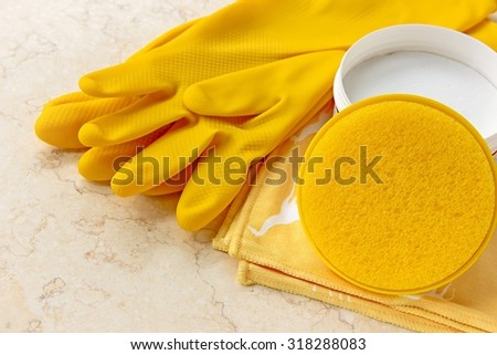 House cleaning tools -  rubber gloves, cleaning cloth, sponge and house cleaning cream on marble.