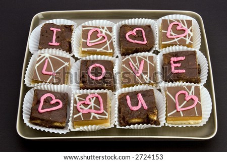 Chocolate cakes with \'I love you\' and \'love hearts\' written in icing.