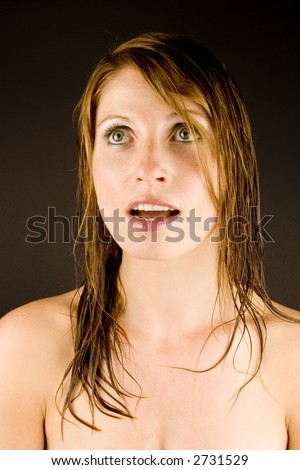 A young woman with a look of surprize against a plain background.