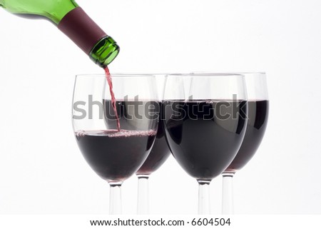 Multiple glasses of red wine being poured against a plain background.