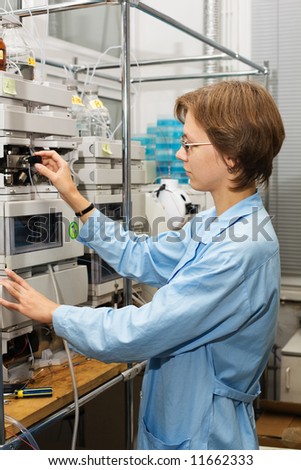 The young nice woman-scientist work with scientific instrument on a background scientific instruments