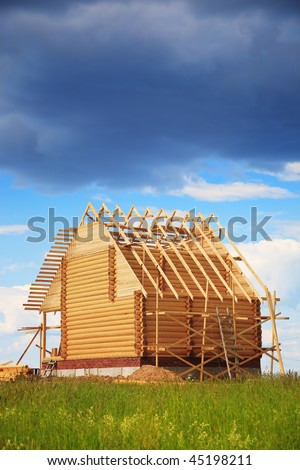 Not completed wooden house under the big dark cloud