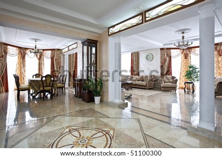 Luxury home interior with lobby, living room and table for dinner in daylight