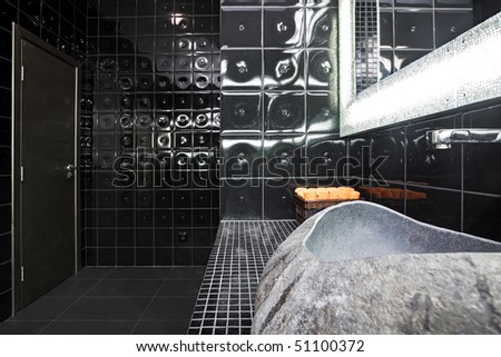 Interior of luxury black restroom with natural stone sink