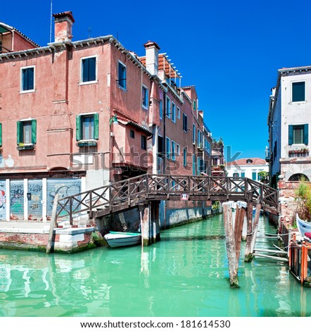 View of beautiful colored Venice canal with bridge and houses standing in water, Italy