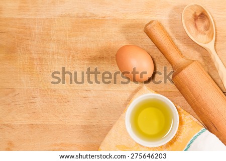 homemade baking. Kitchen rolling pin, spoon, towel, olive oil, chicken egg on vintage cutting old Board