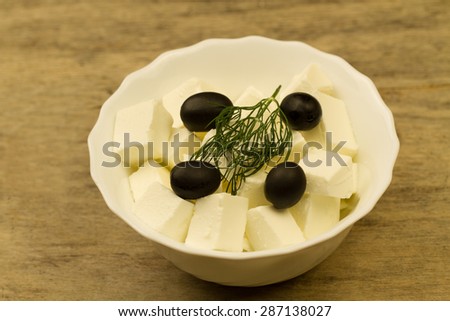 Feta cheese with traditional Greek olives on wooden background