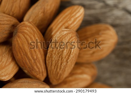 peeled almonds on wooden background. For vegetarians