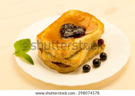 fresh french toast with honey and jam on a white plate with berries. healthy diet