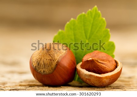 hazelnuts with leaves on old wooden background. Healthy vegetarian food