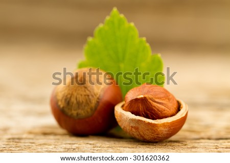 hazelnuts with leaves on old wooden background. Healthy vegetarian food