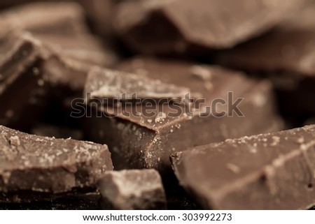 Broken chocolate bar on wooden background, close-up