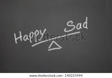 Blackboard with a happy and sad balance Seesaw
