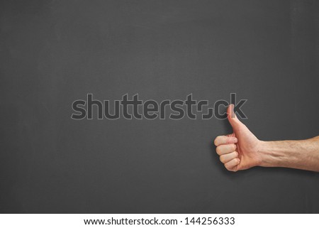 Mans hands in front of a chalkboard with thumbs up.