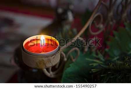 Lit candles and tealights with Christmas decorations on a Table.