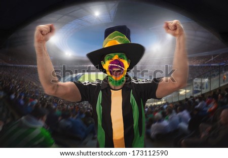 A brazilian football fan celebrating a goal in a football stadium.