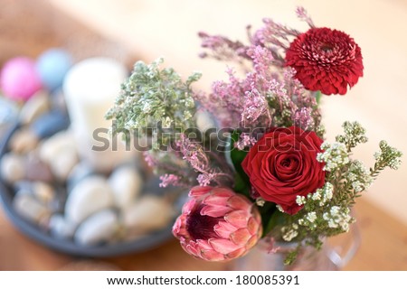 Narrow focus flowers in a vase on a wooden table.