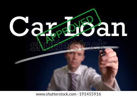 An underwriter writing Car Loan approved on a screen.