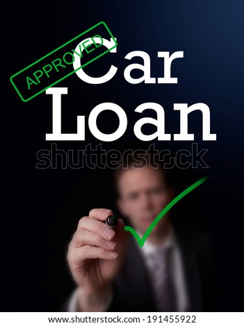 An underwriter writing Car Loan approved on a screen.