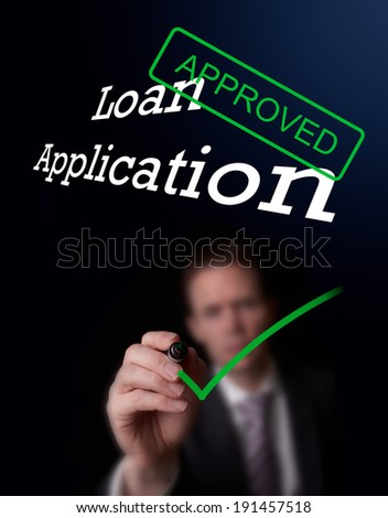 An underwriter writing Loan Application approved on a screen.