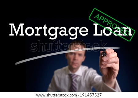 An underwriter writing Mortgage Loan approved on a screen.