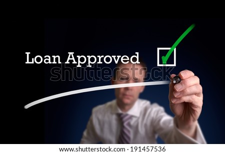 An underwriter writing Loan Application approved on a screen.