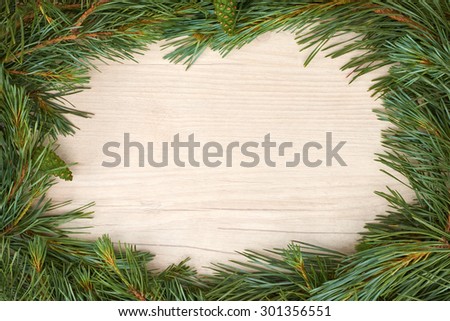 Traditional pine tree Christmas border decoration on a wood background.