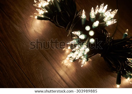 Traditional Christmas Tree lights lying on a wooden floor.