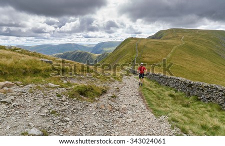 A man fell running down from The Knott and on towards the summit of High Street in the English Lake District, UK.
