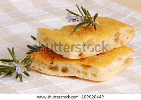 Pieces of italian bread focaccia and fresh rosemary herb.Mediterranean italian typical food.