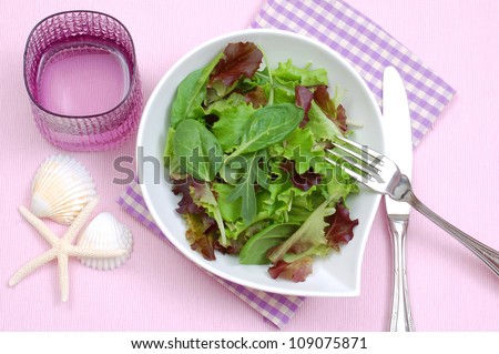 Green lettuce, arugula and spinach salad on plate, top view.Dieting concept, summer light salad
