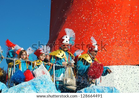 VIAREGGIO, ITALY - 10 FEB 2013:Festival, masked dancers on a carnival float, throwing confetti on the streets of Viareggio at the Carnival of Viareggio February 10, 2013 in Viareggio, Italy.