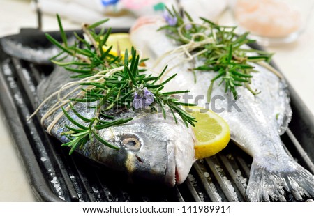 Fresh sea bream fishes on bbq with herbs ready to cook.Mediterranean seafood cuisine, light food, diet concept.