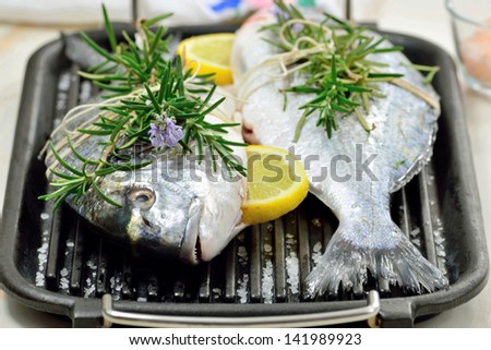 Uncooked gilt head bream fishes with condiments.Mediterranean seafood diet.Italian cuisine.