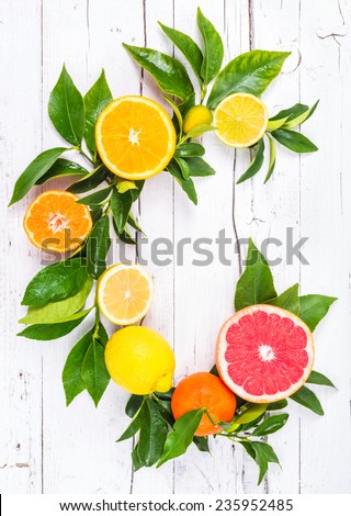 Fresh citrus fruits on white wood background. Vitamin C letter with fruits.