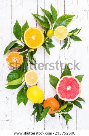 Fresh citrus fruits on white wood background. Letter C fruits.
