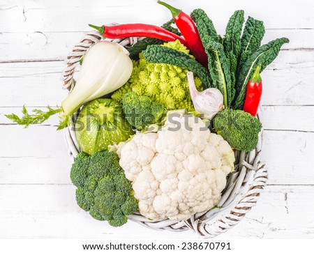 Vegetables on white rustic background.Winter veggies, broccoli, cauliflower,romanesco broccoli,onion, fennel, kale, chile peppers in basket.