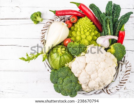 Vegetables on white rustic background.Winter veggies, broccoli, cauliflower,romanesco broccoli,onion, fennel, kale, chile peppers in basket.