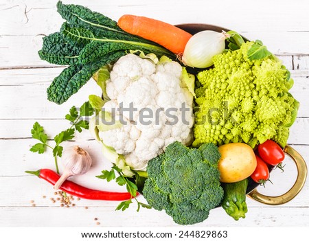 Vegetables in pot on white rustic background.Winter veggies.Healthy cooking concept.