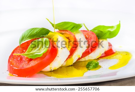 Mozzarella and tomatoes, caprese salad.Italian food, cuisine.Restaurant menu plate closeup.