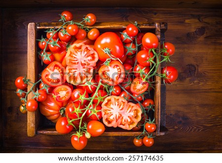 Tomatoes.Mix tomatoes on rustic wood background.Red tomatoes food background, still life.