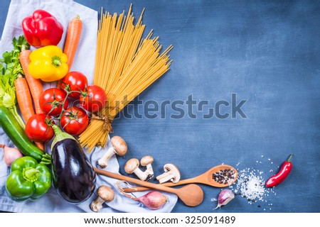 Cooking background with vegetables on chalkboard, whole wheat pasta, text box.Vegan, vegetarian food background.