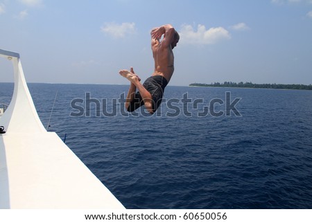 Man jumping from boat into the sea