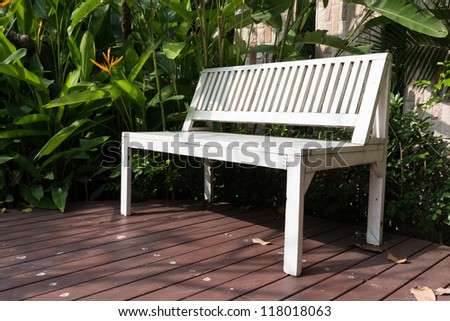 white bench on wood path in garden