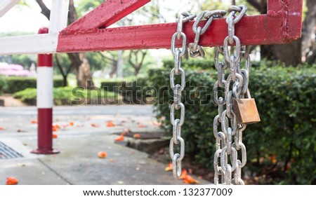 steel chain cross lock master padlock on red road barrier