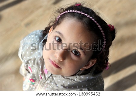 Cute 5 years old girl look straight to the camera with neutral expression
