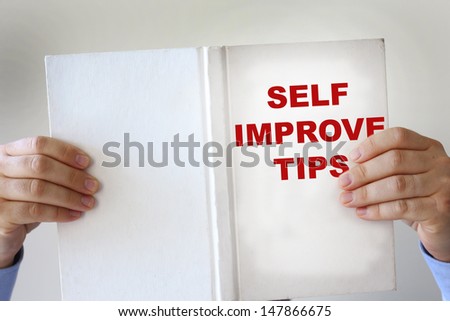 Hands holding a self improvement how to book