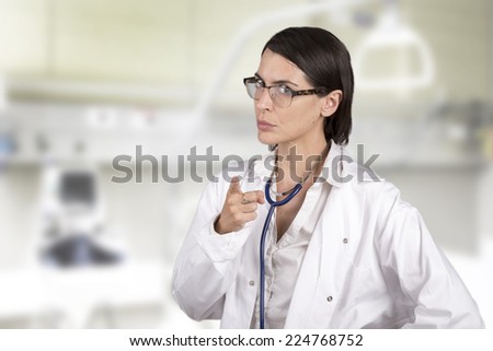 Female doctor in uniform stand in a hospital room and warn the patient